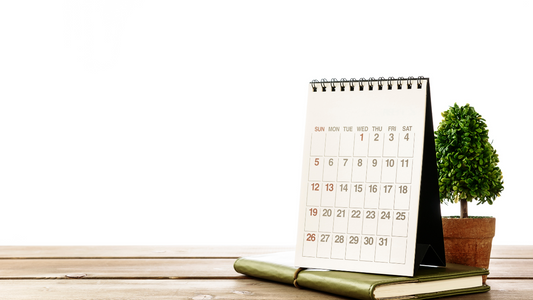 a desk calendar on top of a notebook 