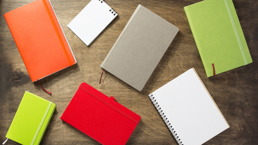 multiple notebooks, diaries, and planners on a desk